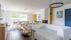 Ein modernes Wohnzimmer mit Sofa, Couchtisch und Essbereich.