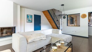 Ein modernes Wohnzimmer mit einer Couch, einem Glastisch und einer Treppe.