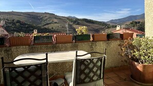 A terrace with a table and chairs, overlooking a hilly landscape with terraced fields. - Family house 4 rooms 8 people, near the beach in Banyuls-sur-Mer (Banyuls-sur-Mer)