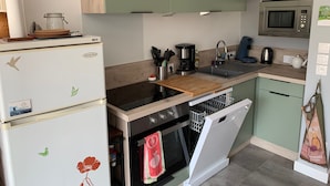 A compact kitchen with a refrigerator, stove, oven, and dishwasher. - Family home between beach and bay with private parking (Fort-Mahon-Plage)