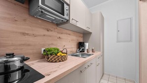 A kitchen with a microwave, a stove, a sink, and a wooden countertop. - “Apartment Föhr” in the heart of Büsum with balcony, centrally located and close (Büsum)