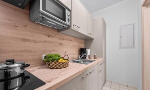A kitchen with a microwave, a stove, a sink, and a wooden countertop. - “Apartment Föhr” in the heart of Büsum with balcony, centrally located and close (Büsum)