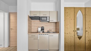 A compact kitchen with a microwave, coffee maker, and sink. - "Ferienwohnung Krebs" in the heart of Büsum with balcony and close to the beach (Büsum)
