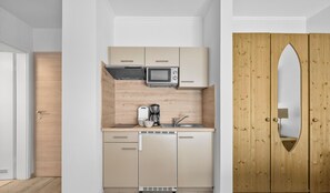 A compact kitchen with a microwave, coffee maker, and sink. - "Ferienwohnung Krebs" in the heart of Büsum with balcony and close to the beach (Büsum)