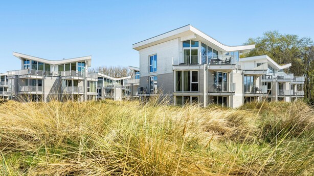 Een modern appartementencomplex met balkons en grote ramen.