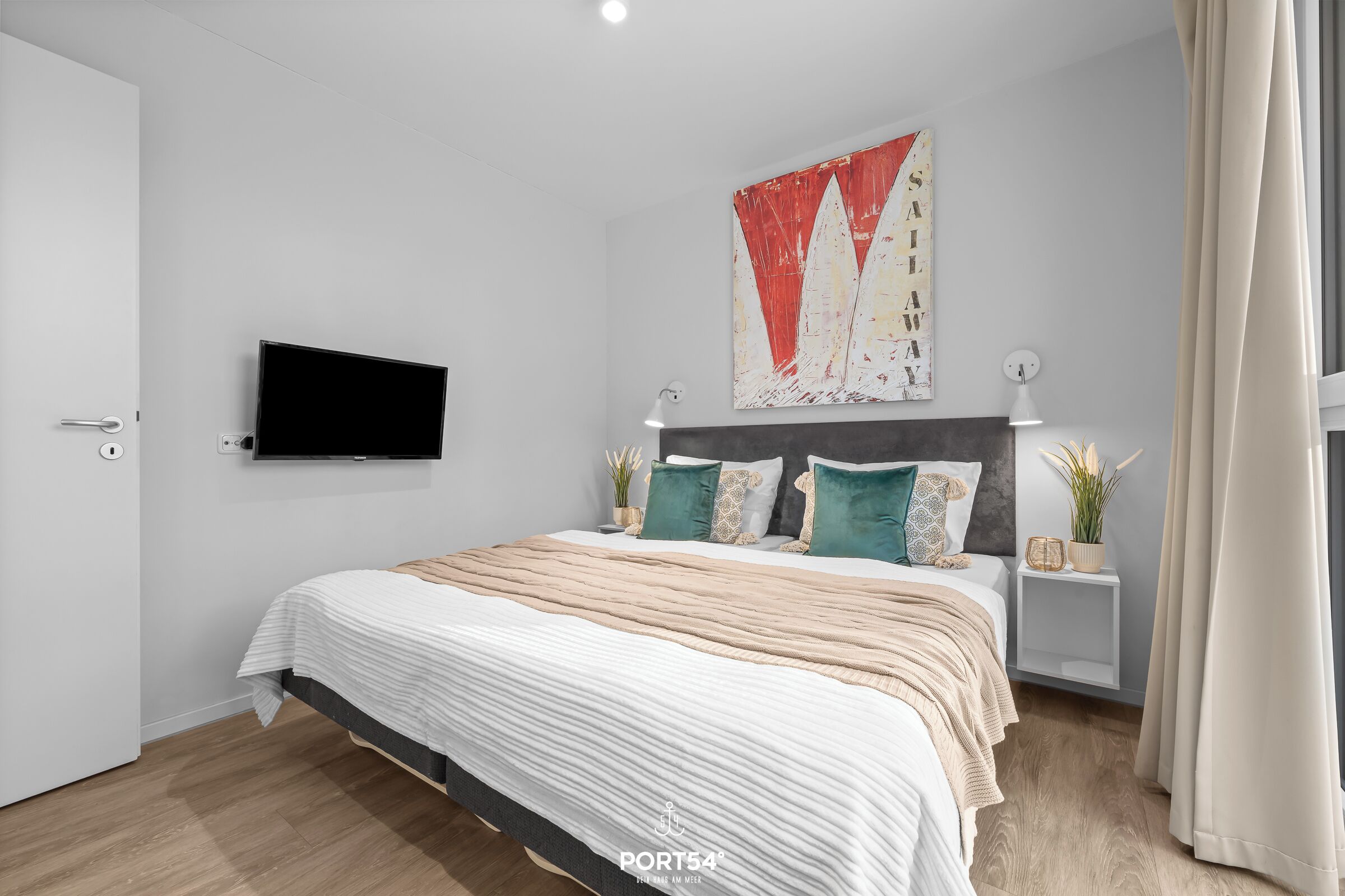 A modern bedroom with a large bed, a flat-screen TV mounted on the wall, and a decorative painting above the bed.