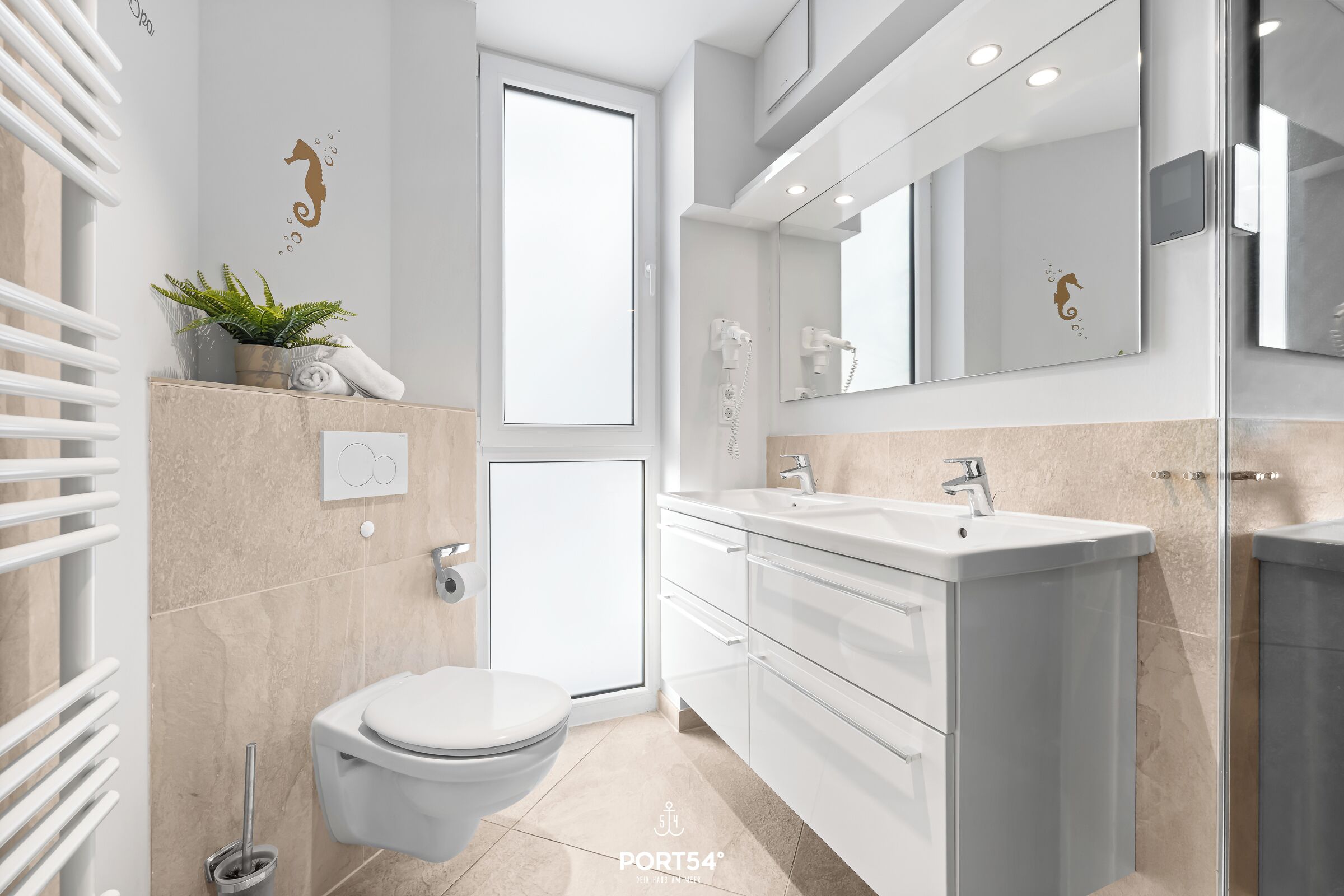 Ein modernes Badezimmer mit Toilette, Waschbecken und Duschbereich.
