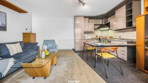 Eine moderne Wohnung mit Wohnzimmer, Küche und Essbereich.