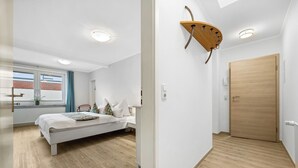 Ein modernes Schlafzimmer mit einem Bett, einer Holztür und einer Wandleuchte.