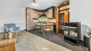 Eine moderne Küche mit Essbereich, einer Couch und einem Kaminofen.