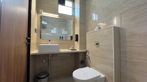 A modern bathroom with a sink, mirror, and toilet.