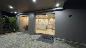 A modern building with a reception area, glass doors, and a tiled entrance. - MALPE RIVIERA (Udupi)