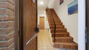 Una escalera con baldosas marrones que conduce a una puerta con el número 2.
