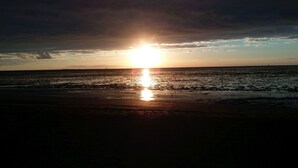 Solnedgang over vand med klar horisont.