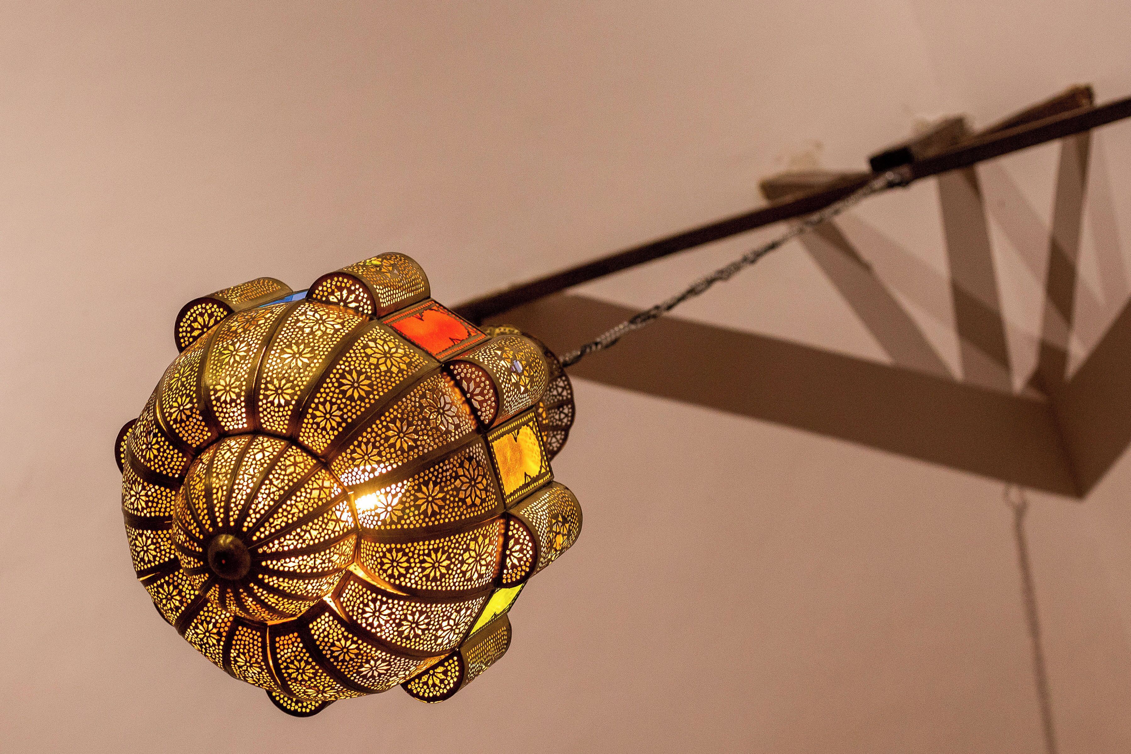 A hanging decorative light fixture with intricate patterns and a visible power cord.