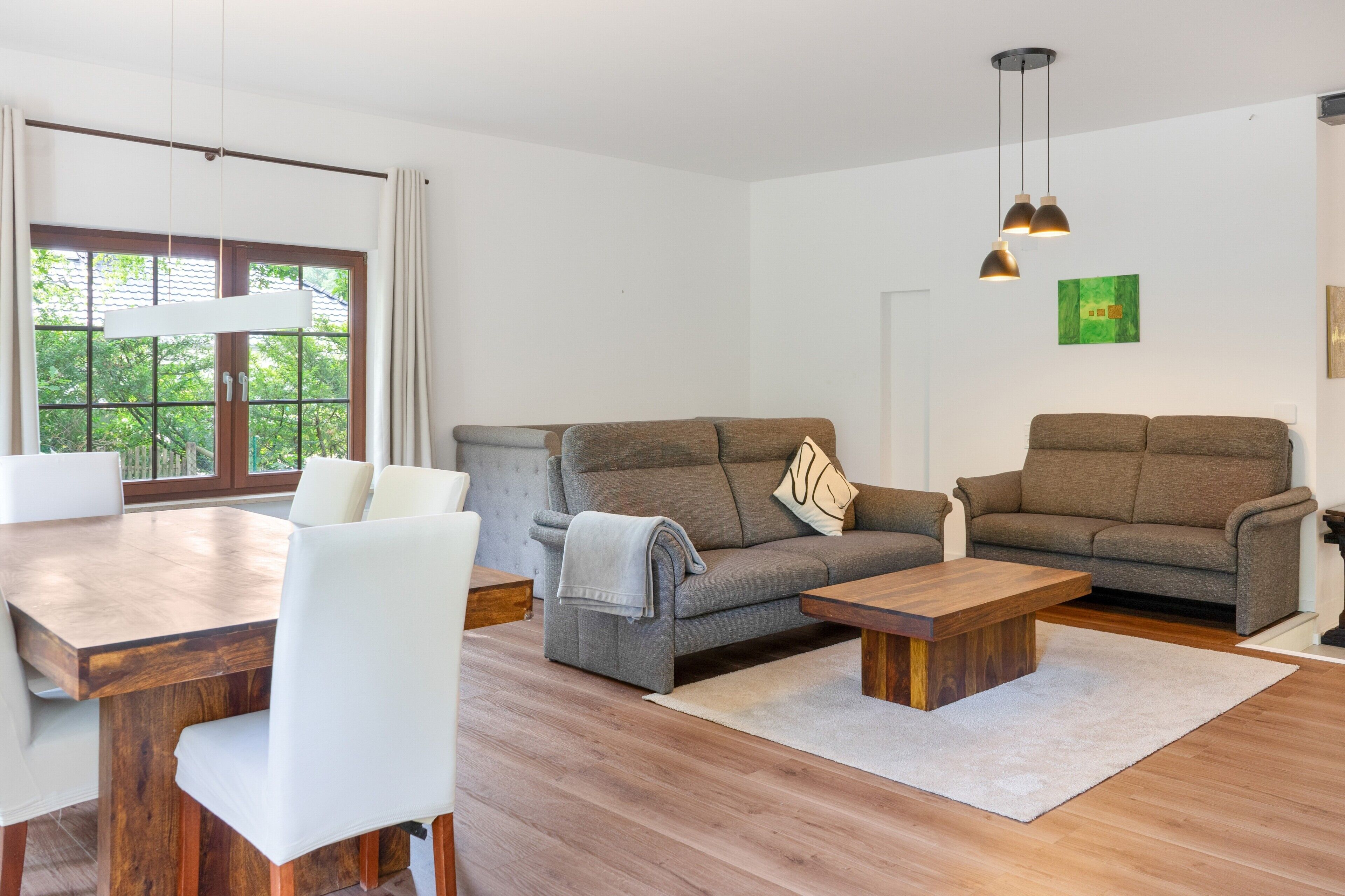 Een moderne woonkamer met een bank, een salontafel en een eettafel.