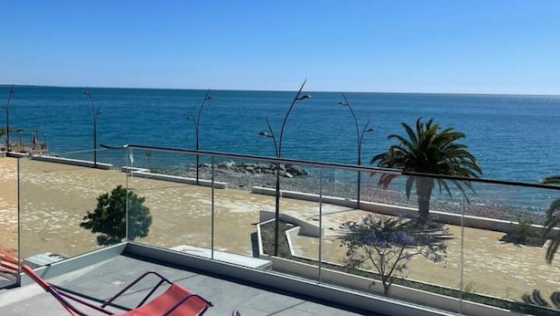 Un balcon avec vue sur la plage et l’océan.
