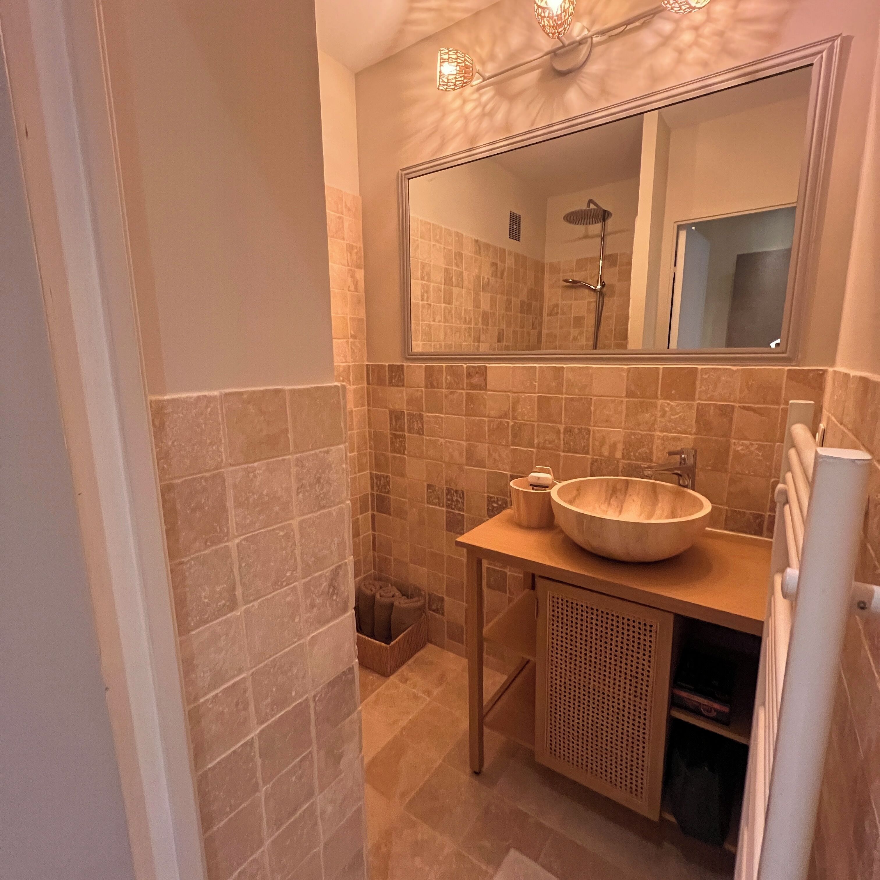 Ein Badezimmer mit einem Holzboden, einem Spiegel und einer Dusche.