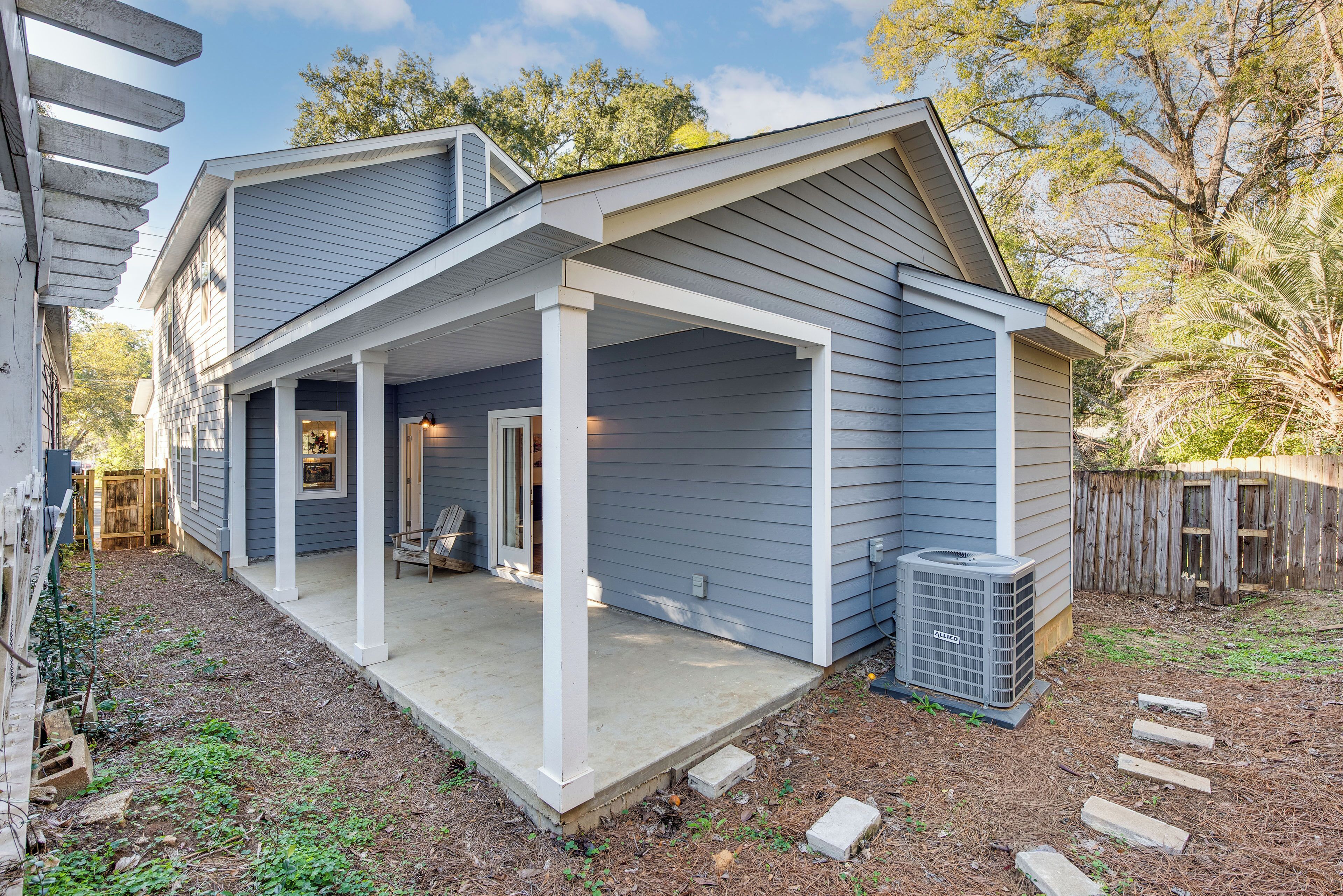 A two-story house with a covered porch and a small backyard.