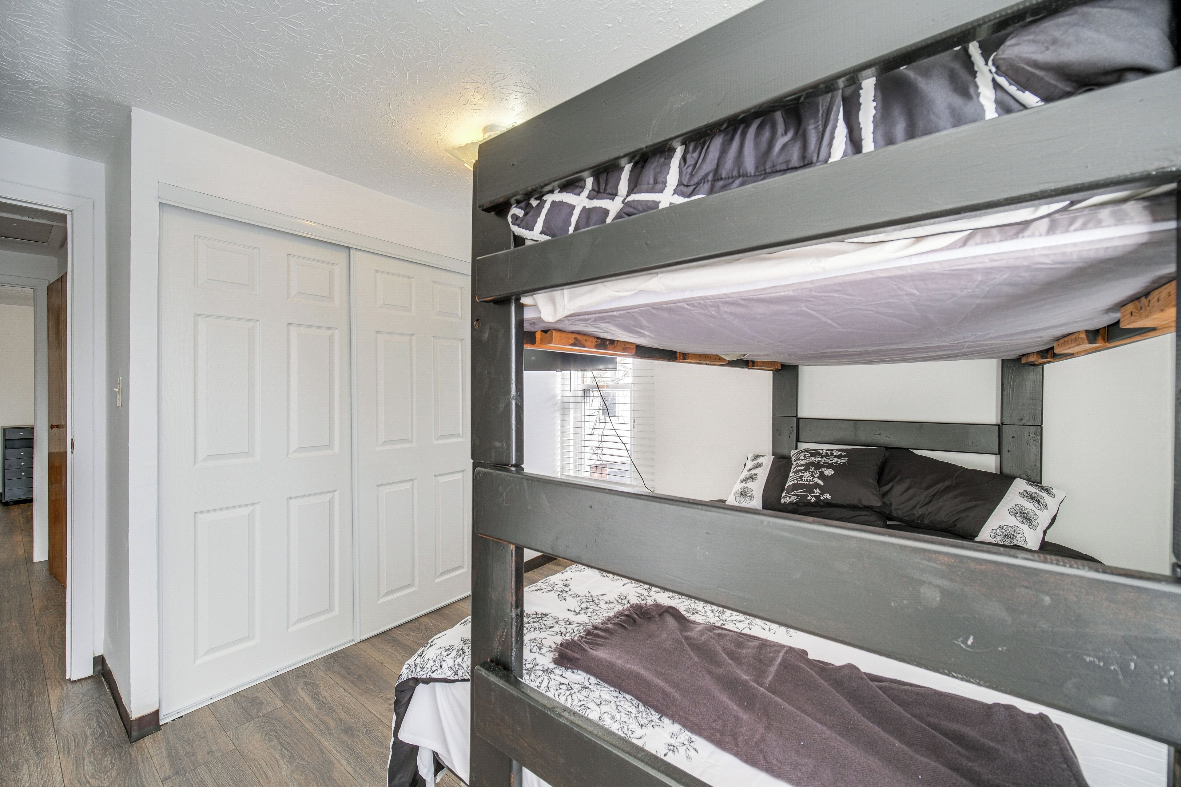 A bunk bed with a white door and a wooden floor.