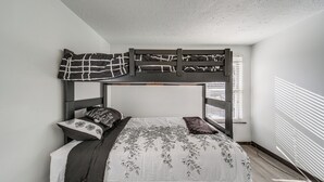 A bunk bed with a headboard and a window with blinds. - Red Line to Airport! Inviting Home in Cleveland (East Cleveland)