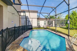 A swimming pool with a safety fence, a hot tub, and a covered patio area. - Golf, Dine & Unwind Poolside! Haines City Getaway (Haines City)