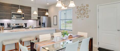 A modern kitchen with a central island, stainless steel appliances, and pendant lighting.