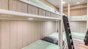 A bunk bed room with a wooden wall and a green carpeted area above the beds. - Mtn & Lake Norris Views: Family Home w/ Game Room! (La Follette)