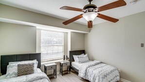A bedroom with two beds, a desk, and a ceiling fan. - Family + Pet Friendly! Garland Home w/ Fenced Yard (Garland)