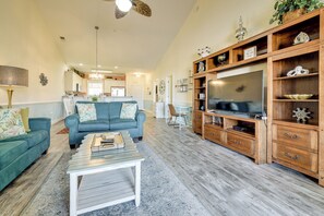 A spacious living room with a blue sofa, a coffee table, and a wooden entertainment center. - 2 Mi to Sea! Myrtle Beach Golf Getaway w/ 4 Pools (Myrtle Beach)