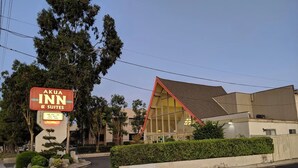 A building with a sign for 'Akua Inn & Suites' featuring amenities like one bed, free WiFi, and a cable pool.