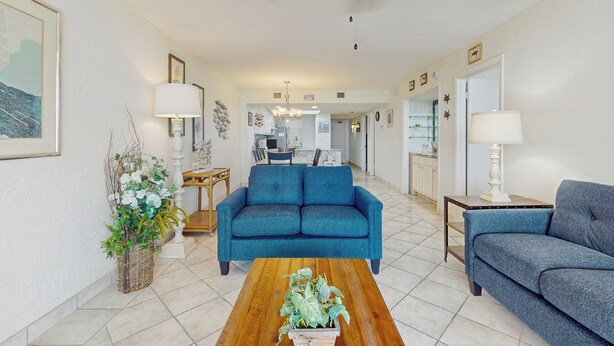 A living room with a blue sofa, a wooden coffee table, and a potted plant. - 2BR w/ Luxury Resort Perks: Suntide III - Unit 507 (South Padre Island)