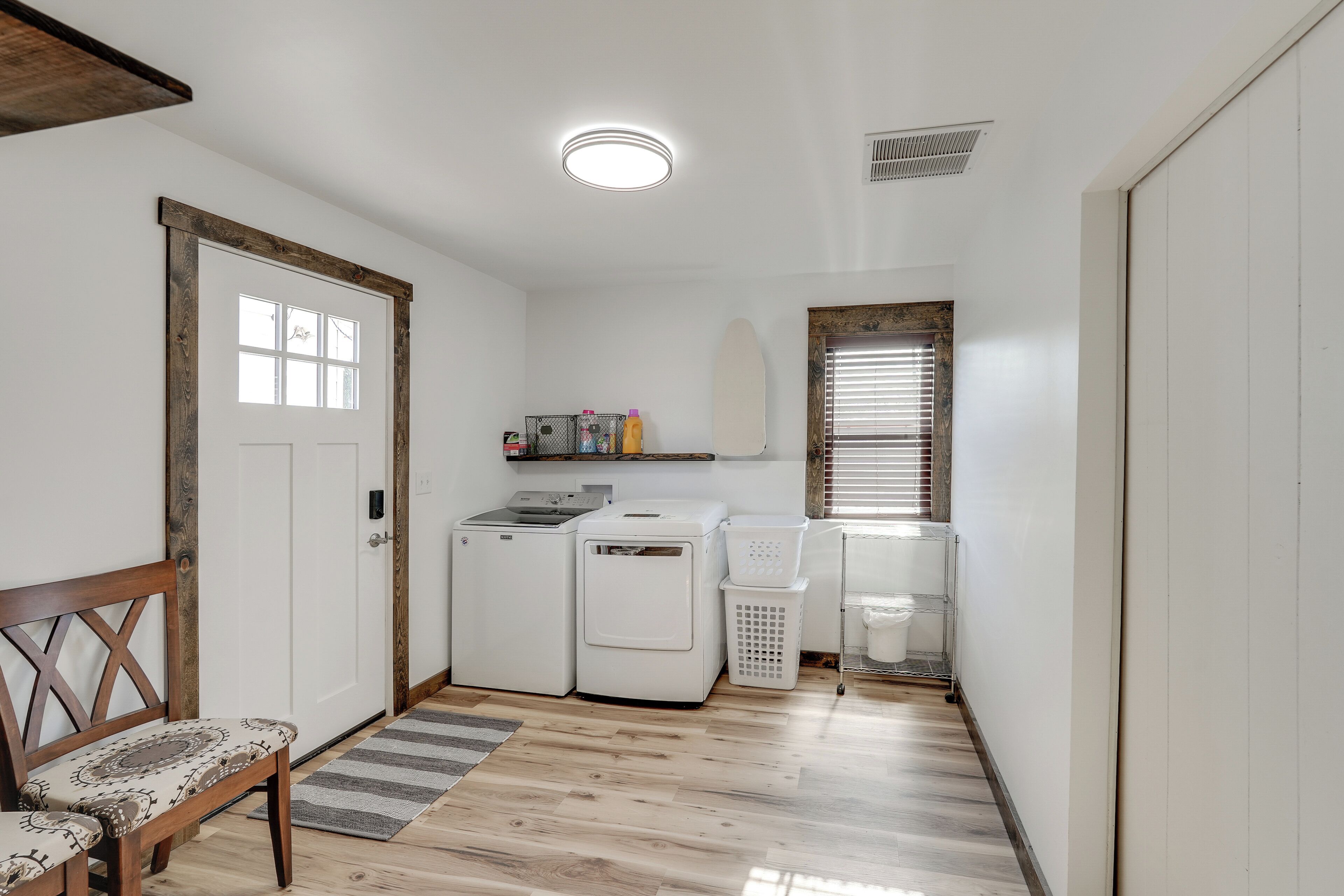 A laundry room with a washing machine, dryer, and stacked laundry baskets.