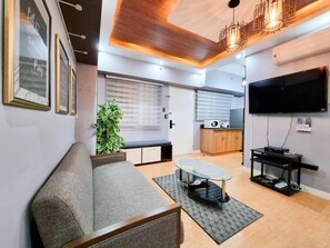 Condo com design assinado, 2 quartos, para não fumantes, sacada | Área de estar | Smart TV 49 polegadas com canais digitais, livros