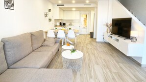 A modern living room with a sofa, chairs, a coffee table, and a TV. - Spacious 3-bedroom semi-detached house in kilometer 14 (La Manga del Mar Menor)