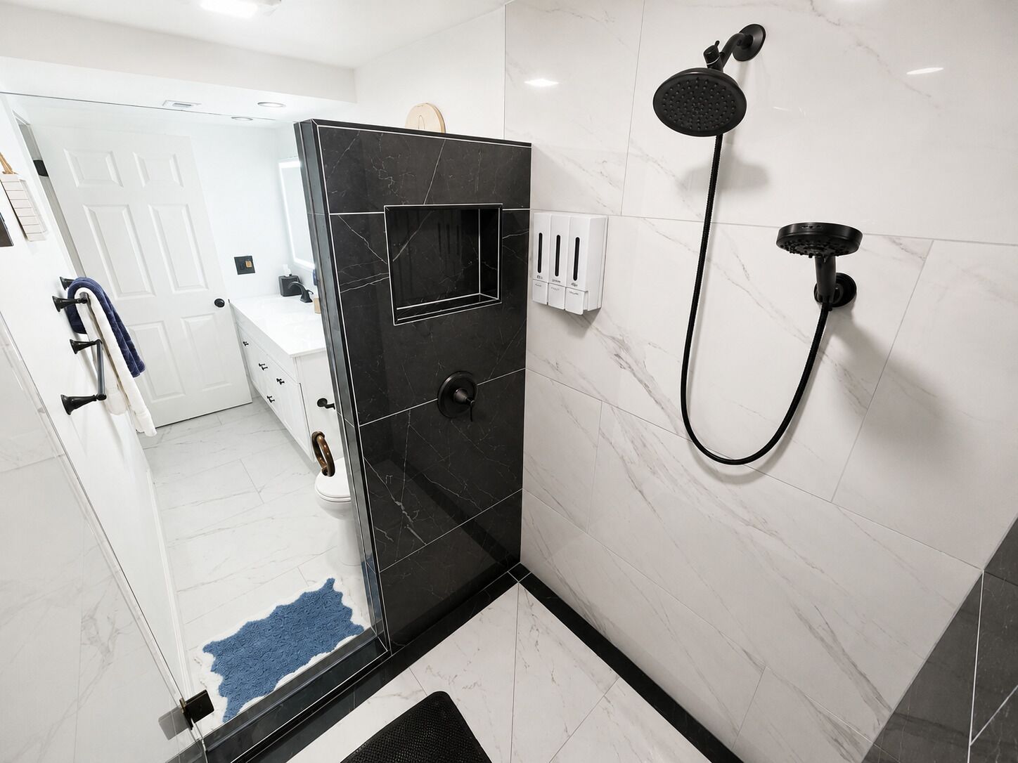 A modern bathroom with a shower, a toilet, and a sink.