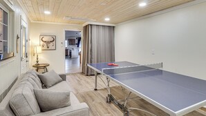 A room with a ping pong table, a sofa, and a lamp. - Cute Home w/ Boat Parking, Monthly Specials (Lake Havasu City)