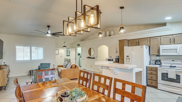 A spacious kitchen with a dining area, wooden cabinets, and a central island. - Cute Home w/ Boat Parking, Monthly Specials (Lake Havasu City)