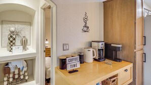 A kitchen with a coffee station, a cabinet, and a wall art piece. - Cute Home w/ Boat Parking, Monthly Specials (Lake Havasu City)