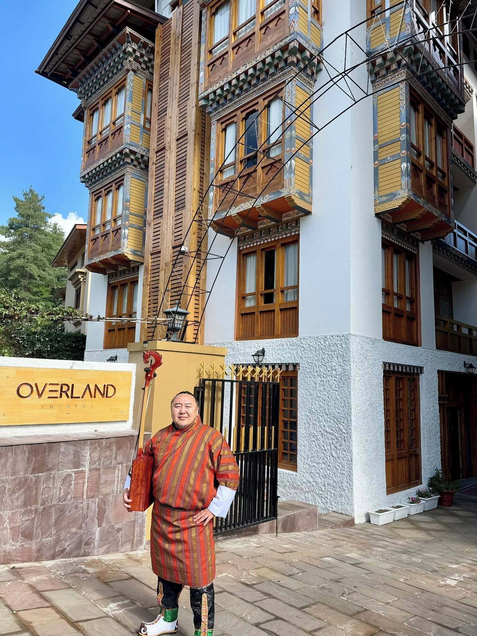 Um edifício tradicional com uma placa que diz 'OVERLAND THIMPHU'.