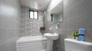 A modern bathroom with a bathtub, sink, and toilet. - Alps motel (Incheon)