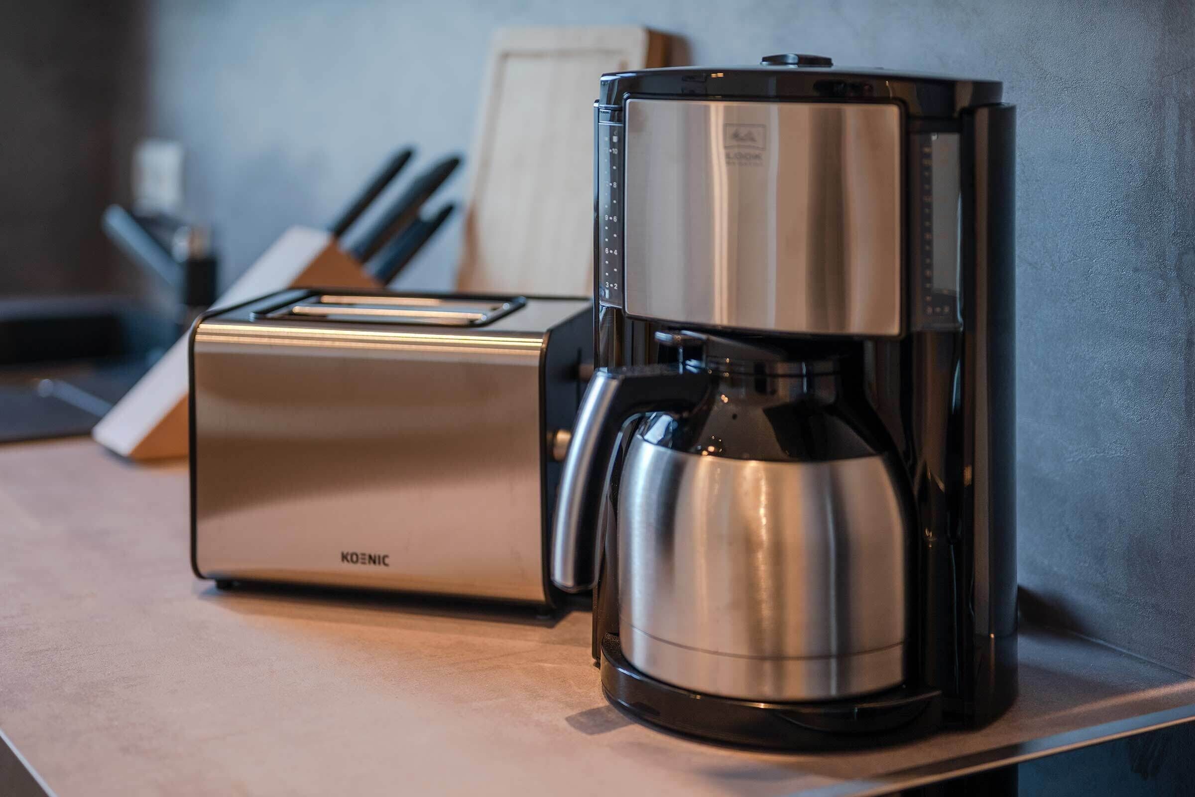 A kitchen with a toaster and a coffee maker on a countertop.
