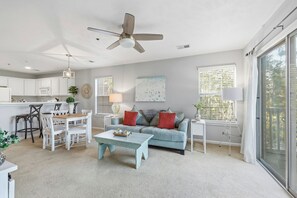 A modern living space with a kitchen, dining area, and seating area. - TB 54G 2-bedroom True Blue Condo (Pawleys Island)