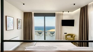 A modern bedroom with a large bed, a TV mounted on the wall, and a view of the ocean. - New Luxury Villa w/ Private Pool, Spa & Sea Views! (Heraklion)