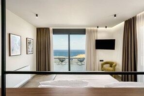 A modern bedroom with a large bed, a TV mounted on the wall, and a view of the ocean. - New Luxury Villa w/ Private Pool, Spa & Sea Views! (Heraklion)