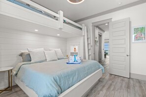 Une chambre moderne avec un lit, une petite table de chevet et une porte donnant sur une autre pièce.
