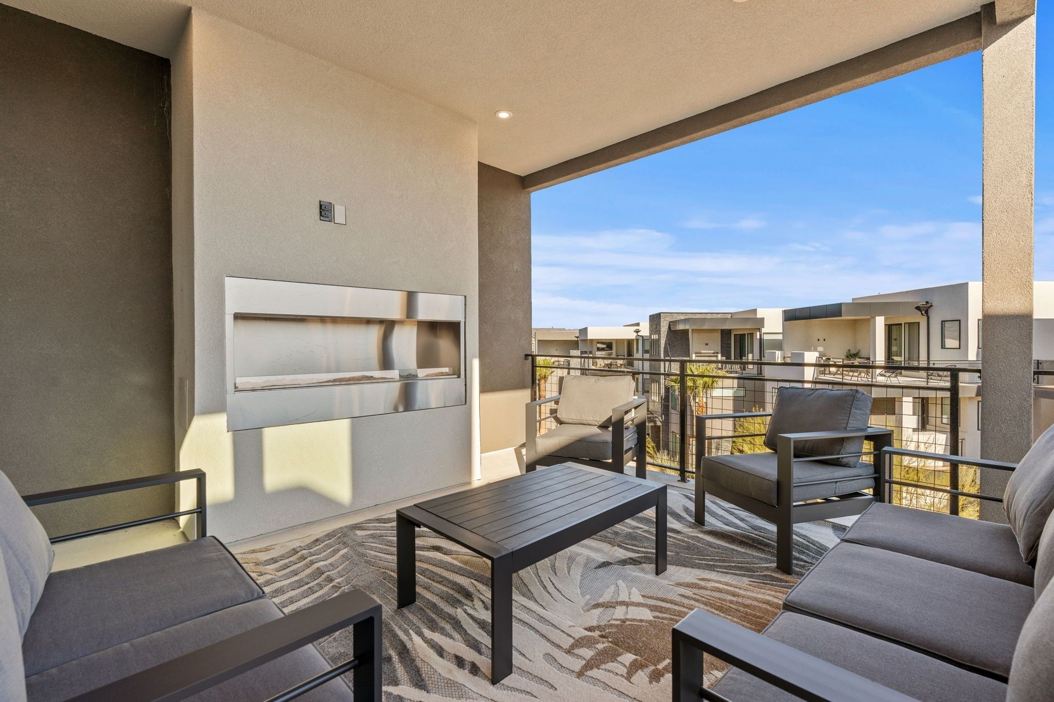 A balcony with a sofa, chairs, and a table.