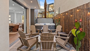 A modern outdoor patio with Adirondack chairs, a hot tub, and a bamboo wall. - Simply Paradise 5 Bedroom Townhouse (St. George)