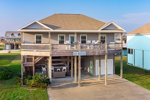 A two-story beach house with a covered deck and a sign reading "SEA WORTHY." - Sea Worthy 3 Bedroom Home (Port Bolivar)