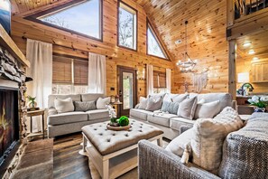 A spacious living room with a high ceiling, wooden walls, and large windows. - Private Luxury Retreat | Hot Tub, Fire Pit & Views (Sevierville)